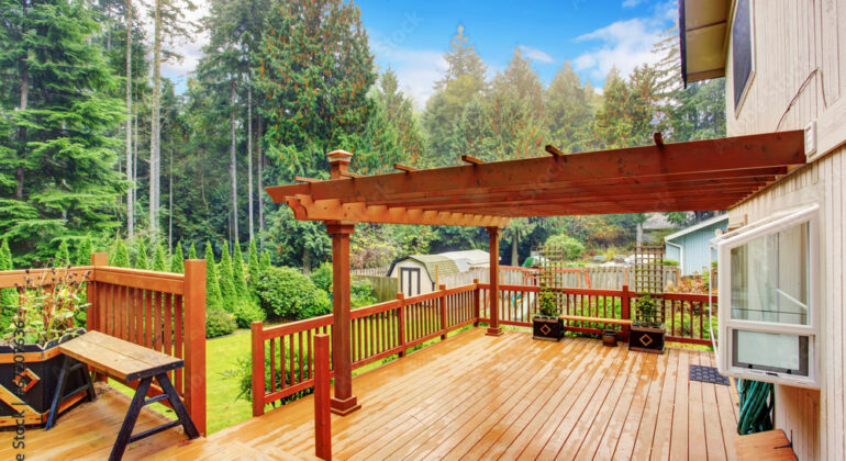 A beautifully crafted wooden deck overlooking a lush backyard